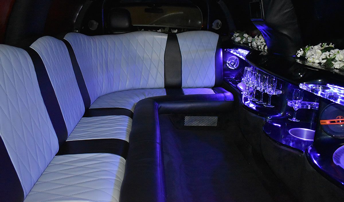 Inside eight-seater white limousine with bar and drinks